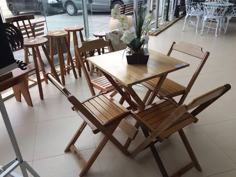 Mesa e cadeiras dobráveis de madeira expostas na loja